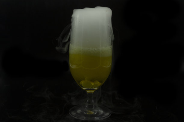 泡沫泡沫和白烟冷却干冰从啤酒装在玻璃万圣节派对花式饮料图片下载