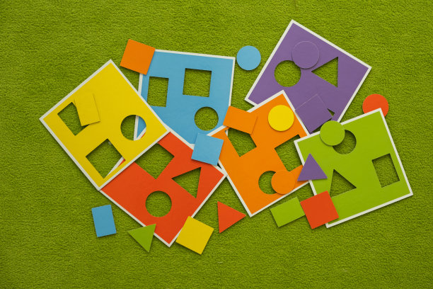 纸板彩色积木为小孩子发展运动技能。绿色草地上的拼图图片下载