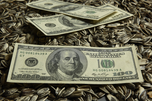 美元纸币与葵花籽、油品的价值观念。图片下载