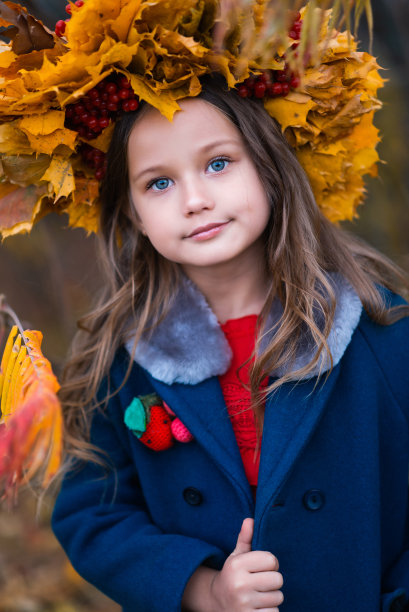 特写肖像的一个孩子与蓝色的眼睛和枫花圈图片下载