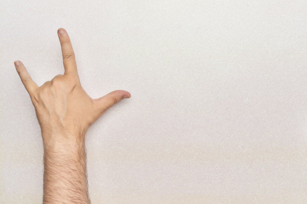 手势喇叭摇滚和滚动滑板与3个手指在白色的背景与闪光图片下载