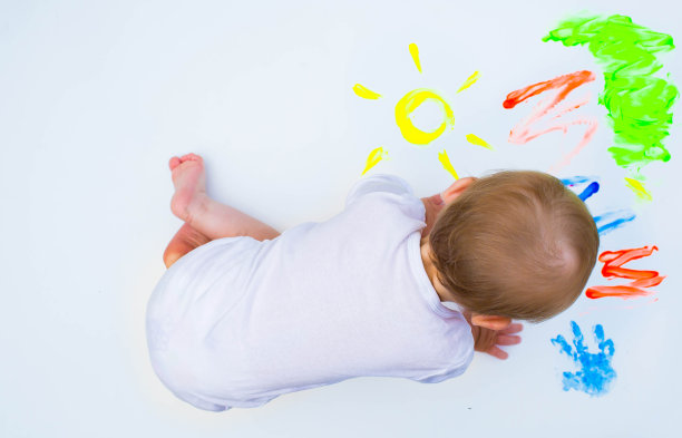 快乐快乐的脏宝宝在白色的背景上玩颜料。快乐休闲，在家玩得开心。孩子的脏手特写。copyspace。图片下载