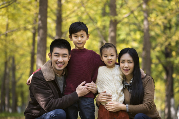 一家四口年轻的父母和孩子在秋天的树林- stock照片图片下载
