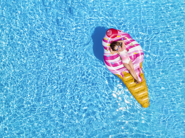 一个金发女孩享受炎热的夏天在一个冰淇淋形状的花车图片下载