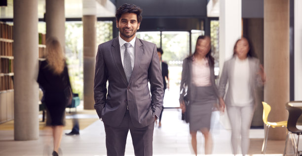 商人站在繁忙的现代写字楼大堂的肖像图片下载