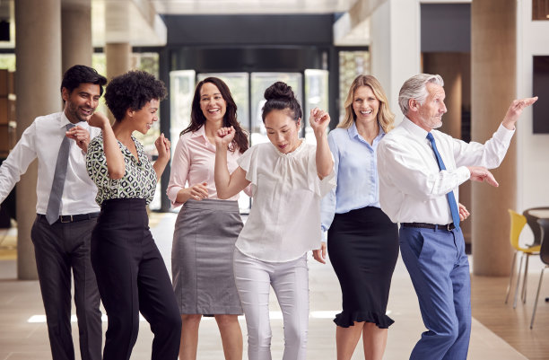 微笑的多元文化商务团队在办公大楼内欢笑的肖像图片下载