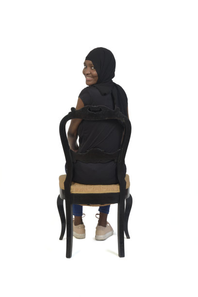 一个女人坐在白底椅子上的全貌图片下载