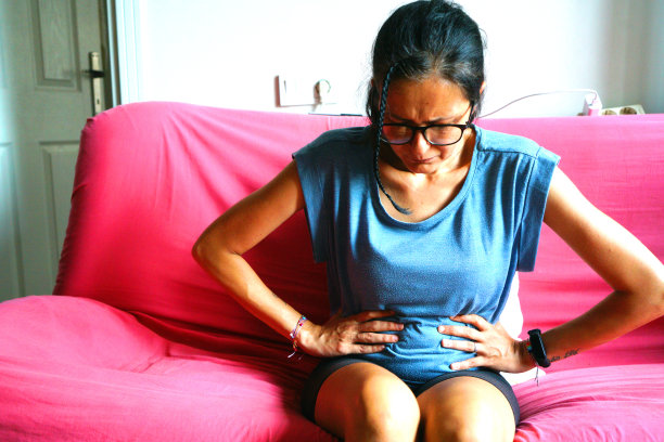 不健康的成熟女人抱着肚子，痛苦不堪图片下载