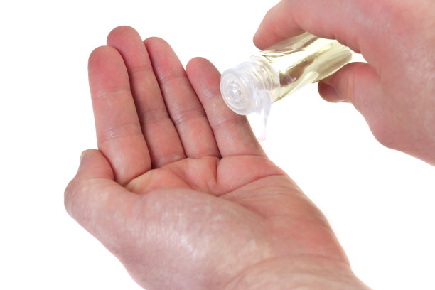 近距离白人青年男子浇淡古龙水到他的手在孤立的白色背景。图片下载