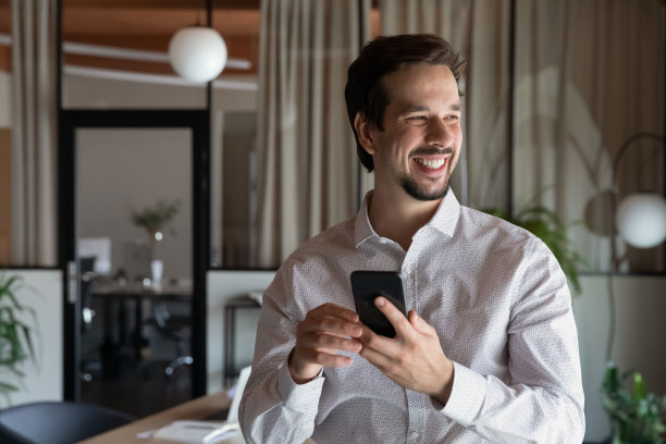 快乐年轻的西班牙商人经理拿着智能手机。图片下载
