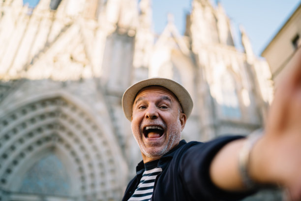 微笑着、情绪激动的游客张大嘴巴自拍照片影响了旅游视频博客的退休生活，兴奋的男博主戴着草帽感受独自度假的快乐和喜悦图片下载