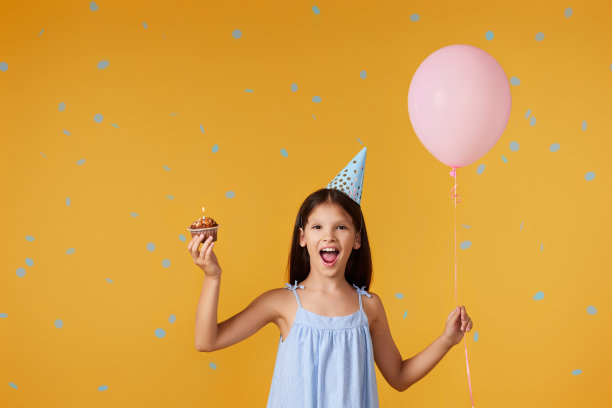 快乐的小寿星和派对甜筒拿着纸杯蛋糕图片下载