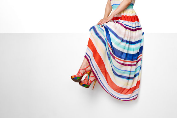 女性腿部穿着条纹夏季连衣裙和粉红色高跟鞋图片下载