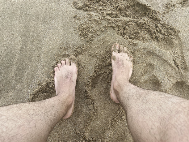 人脚踩沙滩上的沙子图片下载