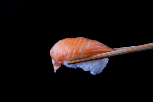用木筷子夹着的三文鱼寿司图片下载