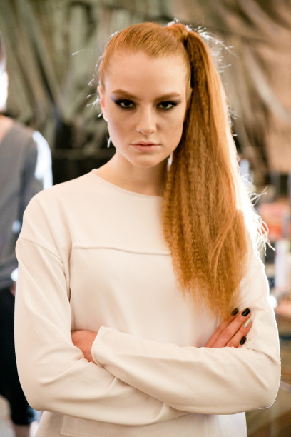 在时装周上工作的时装模特的女性肖像。后台摄影，幕后的新服装收藏。姜黄色发型的女孩穿着时尚设计师图片下载