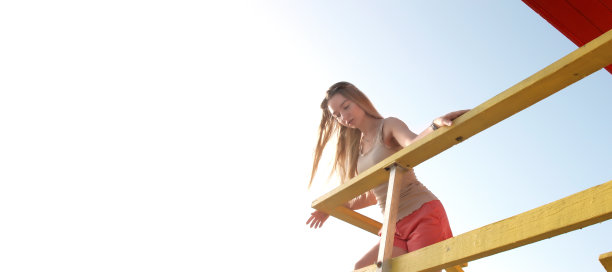 美丽的年轻金发女子户外肖像在救生员小屋在清晨图片下载