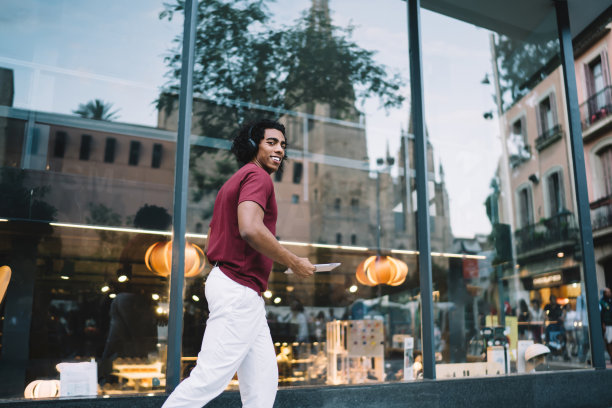 带着耳机和平板电脑在城里闲逛的少数族裔图片下载