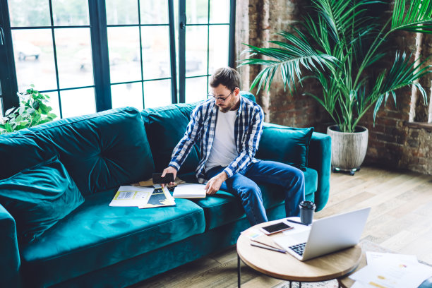 专注的商人在阁楼办公室的沙发上工作图片下载