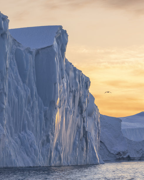 日落时海面上漂浮着巨大的冰山图片下载