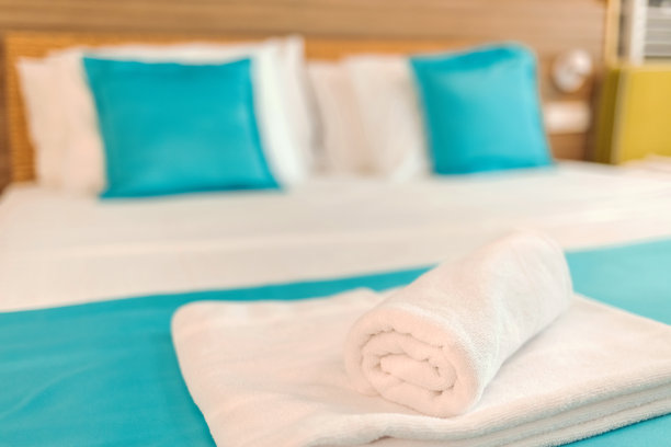 在酒店房间的床上放置干净的毛巾。在酒店房间的床上放置干净的毛巾。酒店客房毛巾，欢迎客人，客房服务。图片下载