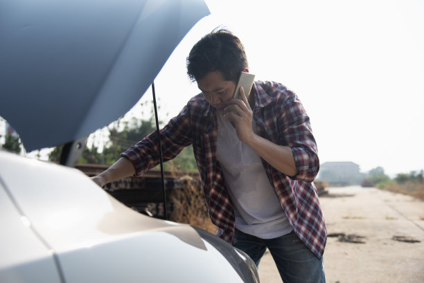 一名男子在路上修理出故障的汽车图片下载