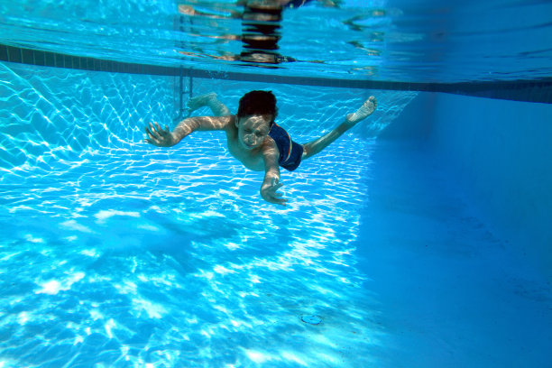 夏天有趣的概念，十几岁的男孩在游泳池水下游泳图片下载