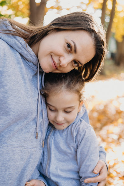公园里母亲拥抱女儿的特写照片。微笑快乐的孩子。家庭护理。家庭的保护。快乐幸福的家庭。家庭日。图片下载