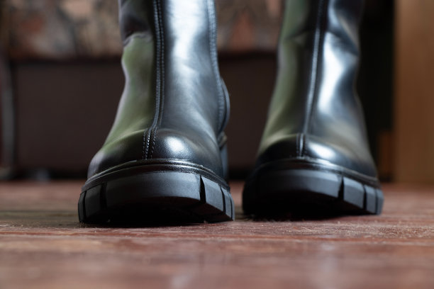 女孩穿着黑色的高筒靴在家里旧脏的地板上，女人的鞋子，脚在地板上，鞋子图片下载
