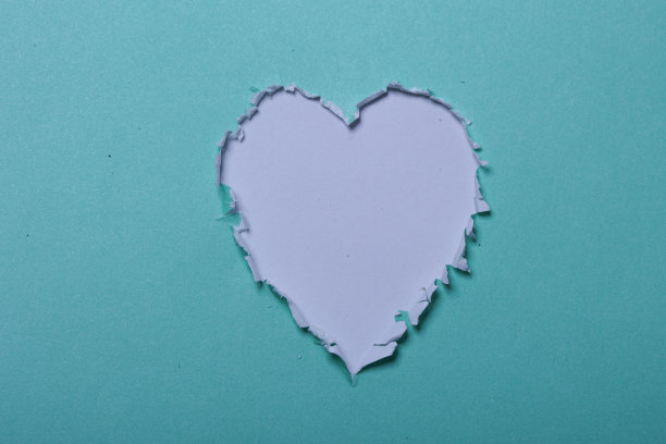 绿纸上的心形洞图片下载