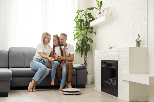 微笑的家人指着机器人吸尘器图片下载