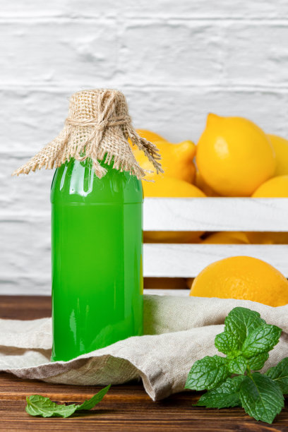 玻璃瓶里的柠檬糖浆和背景箱子里的水果。图片下载