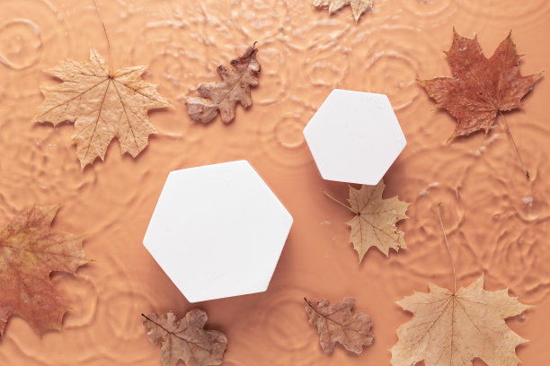 最小的化妆背景与秋叶。白色圆形平台上模糊透明清澈平静的水面与大理石纹理溅起的泡沫。图片下载