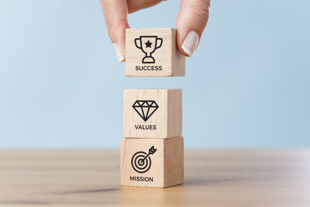 商业理念与木制立方体和女商人的手。公司的使命、价值观和成功。图片下载