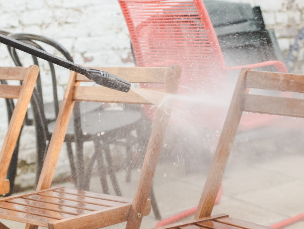 Karcher正在后院清洗花园的木制椅子图片下载