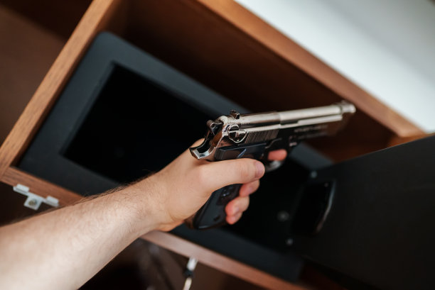 男人从保险箱中取出武器图片下载