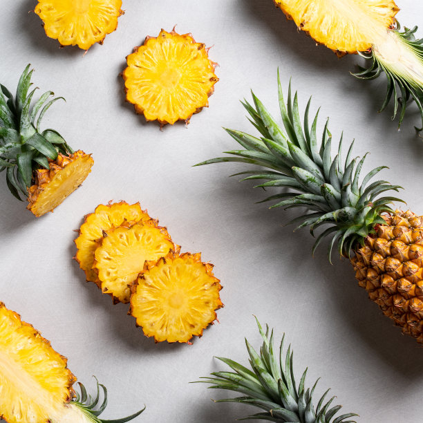 新鲜切下的菠萝，带热带树叶，深蓝色背景。图片下载