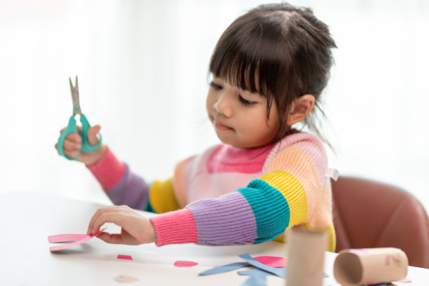 一个亚洲小女孩的肖像剪纸活动在DIY班在学校。剪刀剪纸。图片下载