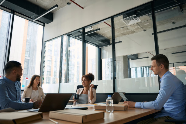 年轻的同事在大的现代办公室的餐桌上开会图片下载