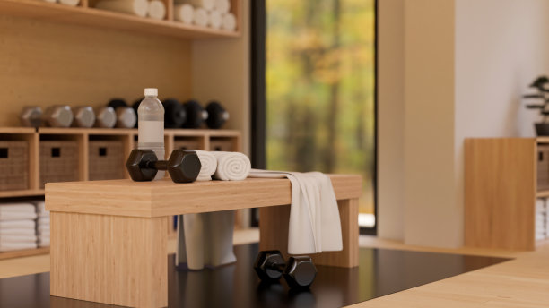 舒适的最小的健身健身房在木制的内部材料与哑铃，毛巾在木座椅上图片下载