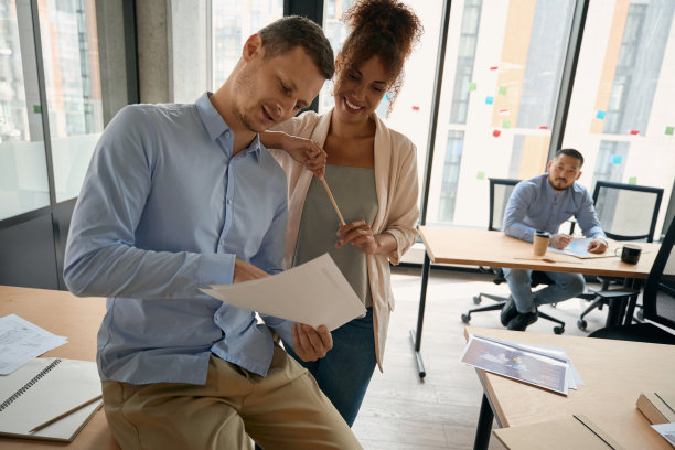在现代合作中，自信的男性向女性同事展示文件图片下载
