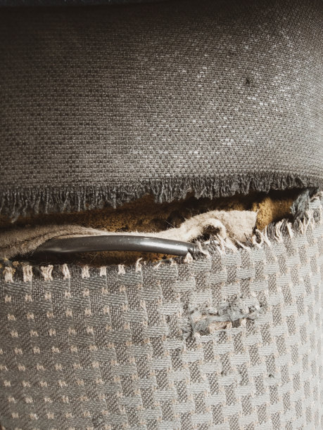 撕破的黑色织物内饰，直到看到黄色海绵，固定垫的概念正在恶化图片下载