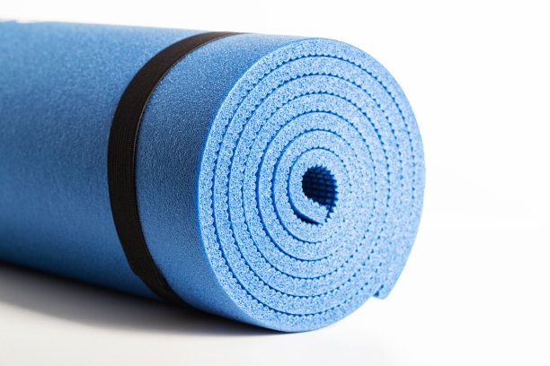 白色背景上的瑜伽和健身班的蓝色垫子，特写。图片下载