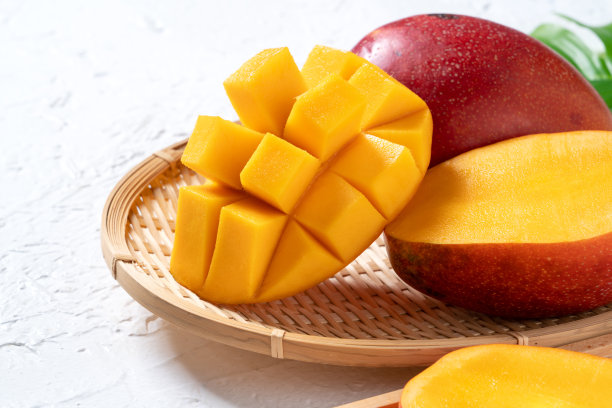 芒果背景设计理念。在白色的桌子上切好的新鲜芒果丁。图片下载