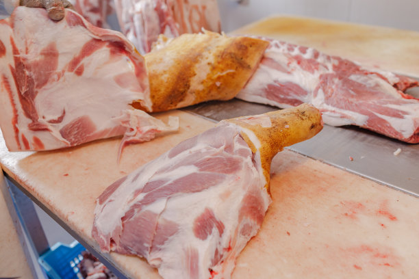 食品工业肉类加工的特写，一名工人切生猪肉，肉制品的概念图片下载