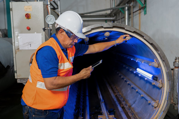 维修工程师在工厂关闭期间对压力罐进行检查图片下载