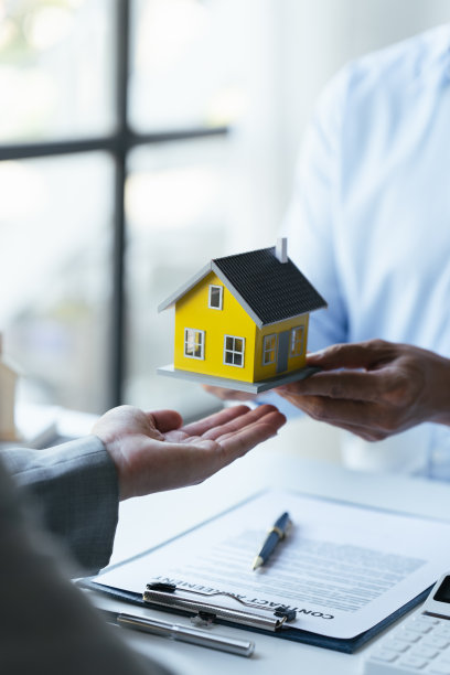 与房地产经纪人的讨论，一名女商人正在签署一份房屋保险合同，一名房地产经纪人正指着合同上的合同向客户解释。图片下载