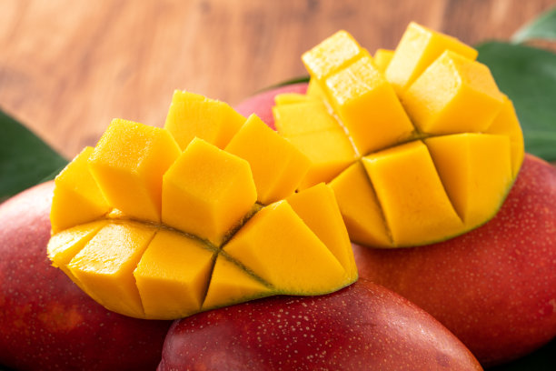 芒果。新鲜芒果的叶子在深色的木制桌子的背景。图片下载