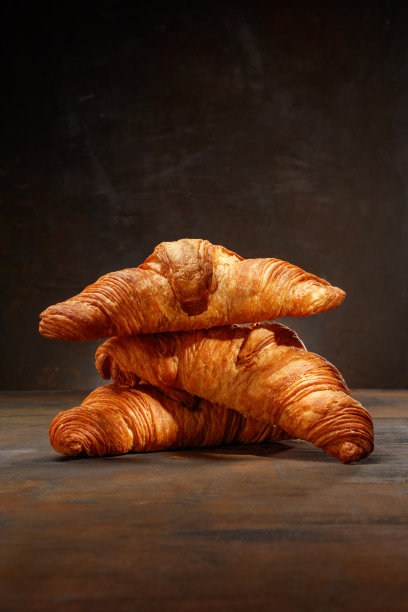 深色生锈的背景上一堆美味的羊角面包的特写。图片下载