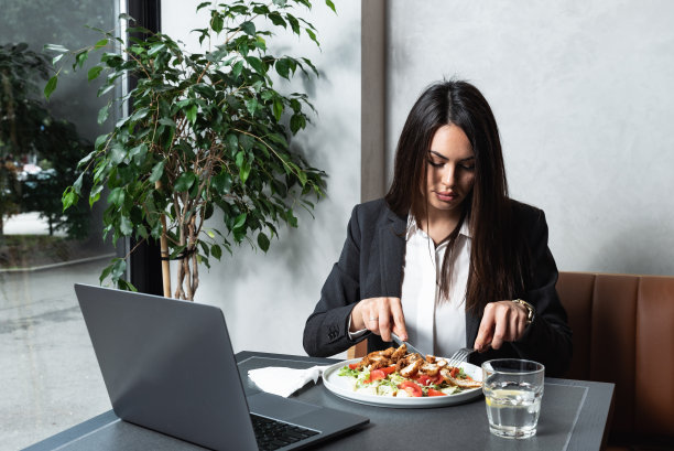 年轻成功的自由职业女性美食博主或视频博主在自助餐厅品尝美味的鸡肉沙拉和蔬菜，并对博客或网络直播视频打分图片下载